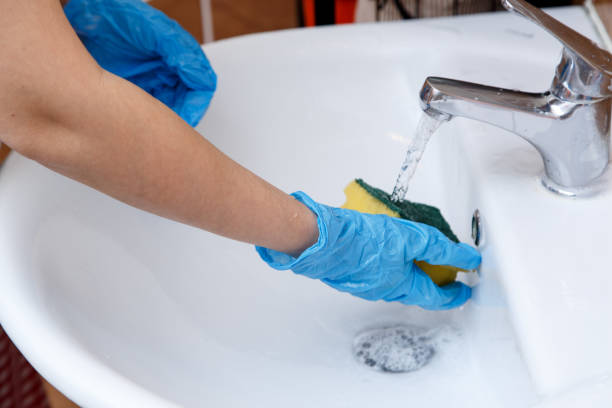 istock women's hands in blue gloves clean the sink 1148997037