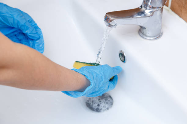 istock women's hands in blue gloves clean the sink 1148997065
