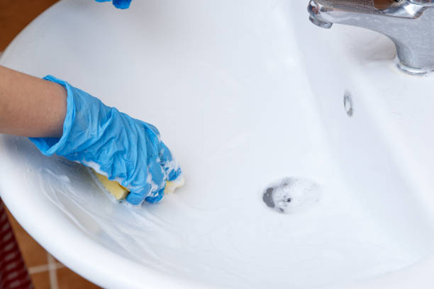 istock women's hands in blue gloves clean the sink 1148997072