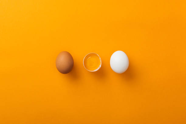 istock top view of two whole chicken eggs with smashed one on bright orange background 1148997529