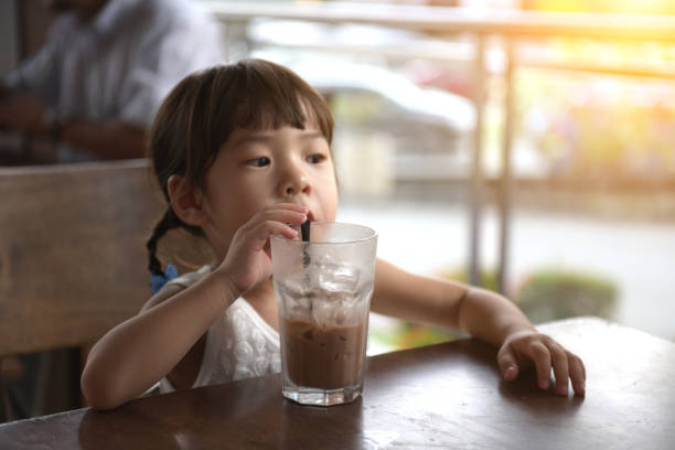 istock little asian girl drinking at cafe 1148997705