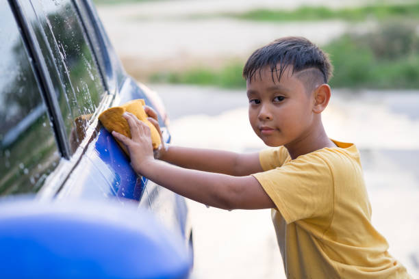 Asian kid boy washing car stock photo