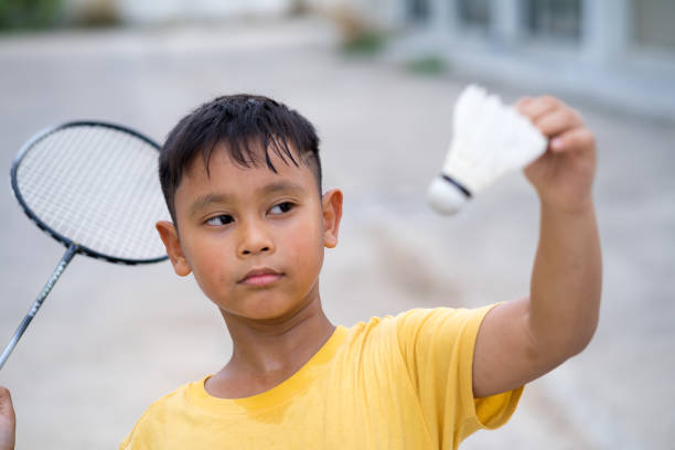 Asian kid boy playing badminton at home stock photo