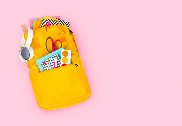 istock Yellow backpack with school supplies isolated on pink background 1149000004