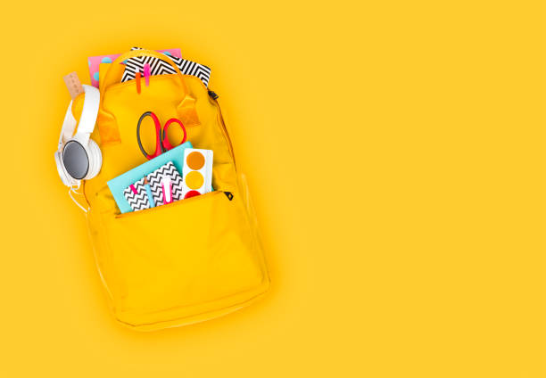 istock Backpack with school supplies and accessories isolated on yellow background 1149000039