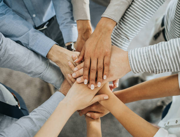 istock Above view of business team gathering their hands in unity. 1149006000
