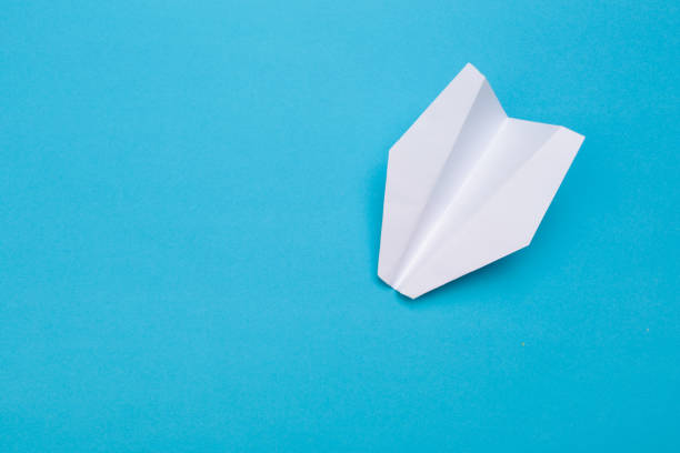 istock Flat lay of white paper planes on blue background with text space. - Image 1149008586