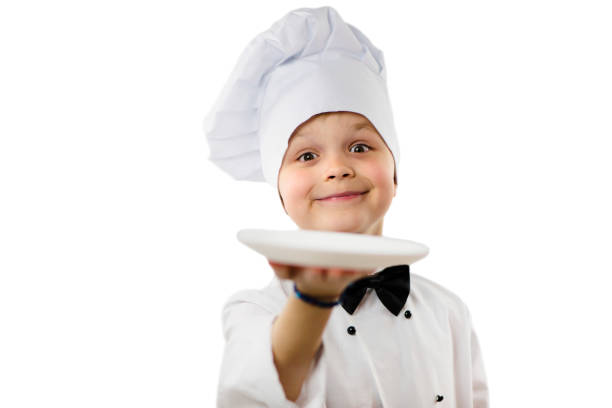 istock cute funny boy chef in uniform holds a clean empty white plate 1149009850