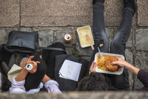 Top view of two people eating takeaway on street at Camden market in London London, UK - 12 September, 2018 - Top view of two people eating takeaway on street at Camden market camden lock stock pictures, royalty-free photos & images