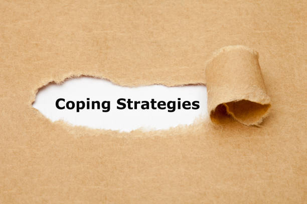 Coping Strategies Torn Paper Concept Text Coping Strategies appearing behind ripped paper. Concept about the series of behavioral and psychological skills and actions needed to handle stressful or unpleasant situations. copek stock pictures, royalty-free photos & images