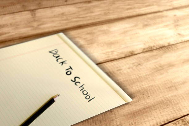 istock Paper and pencil with Back to School message on wooden table 1149011448