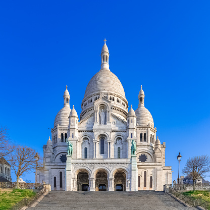 Paris, basilica Sacre-Coeur in Montmartre, touristic monument in blue sky