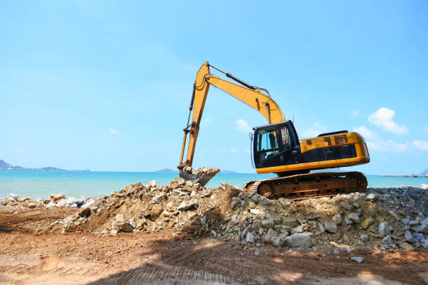 istock excavator digger stone working on construction site - backhoe loader on the beach sea ocean and blue sky background 1149014972