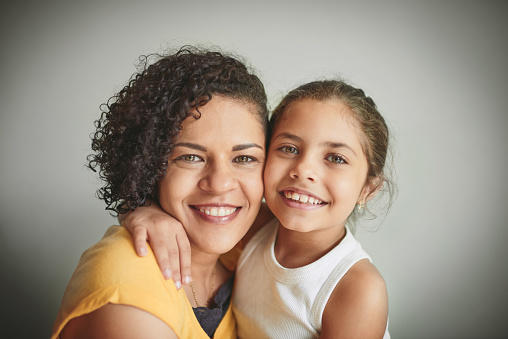 Shot of a woman and her young daughter smiling at the camera
