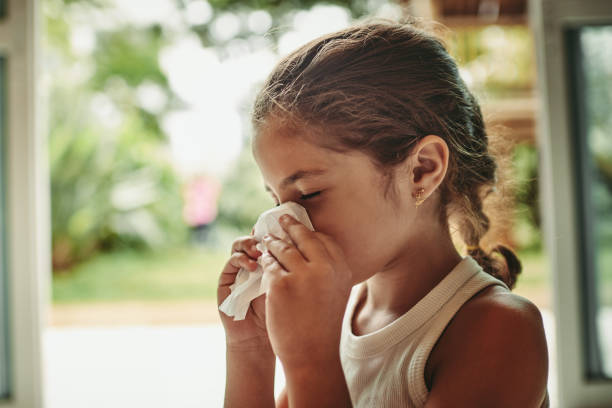 She's feeling under the weather Shot of a young girl blowing her nose cold virus stock pictures, royalty-free photos & images