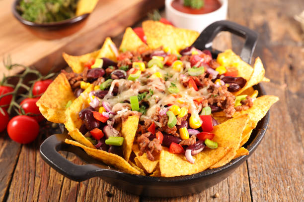 nachos with beef, vegetable and cheese nachos with beef, vegetable and cheese nacho chip photos stock pictures, royalty-free photos & images