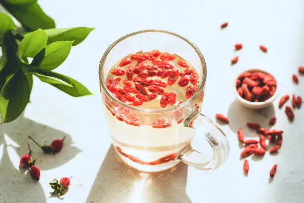 Goji berry infused tea in glass cup. Weight loss, slimming drink and health care concept