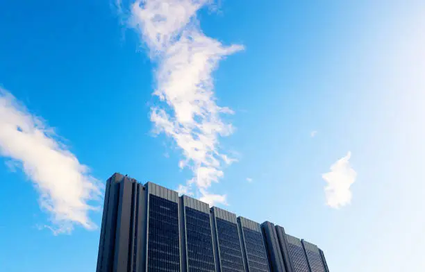 Photo of Looking up at top of skyscraper against lightly clouded sky