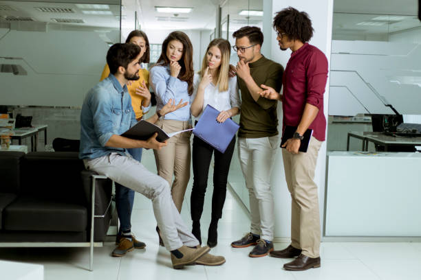 istock Multiethnic group of young people standing in the modern office and brainstorming 1149019601