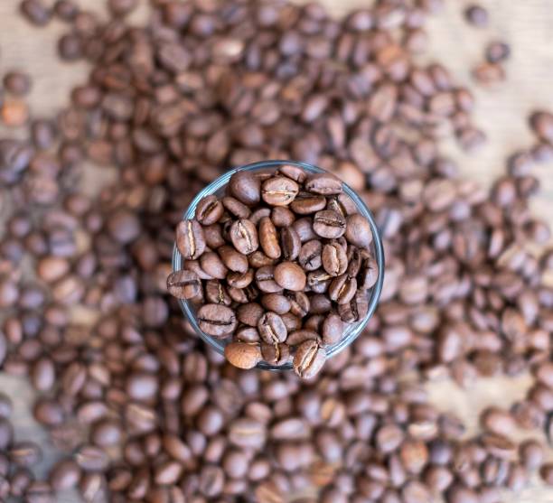 istock Roasted coffee beans inside and surrounding a shot glass 1149023016