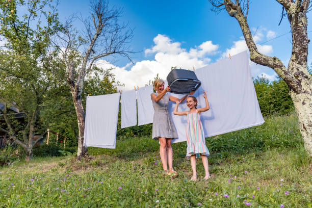 istock Mother and Daughter Having Fun While Hanging Laundry Outdoors 1149024134