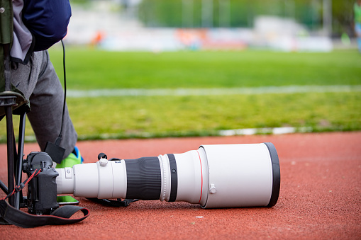 Soccer Match Photographer With Large Telephoto Lens.