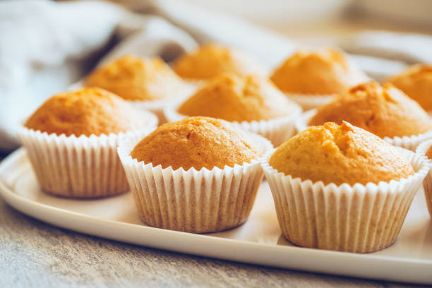 los cupcakes sin escarcha en una placa blanca - muffin fotografías e imágenes de stock
