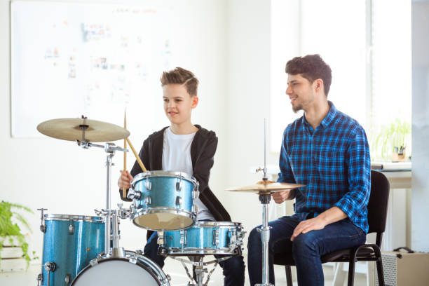 istock Music teacher explaining boy to play drums 1149029971