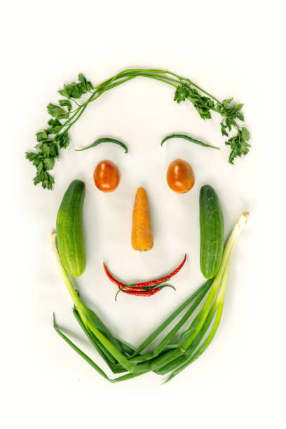 Top view of various fresh vegetables face shape isolated on white