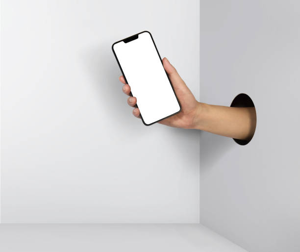 istock Man holding smartphone with blank screen in hand through hole on white background 1149035725