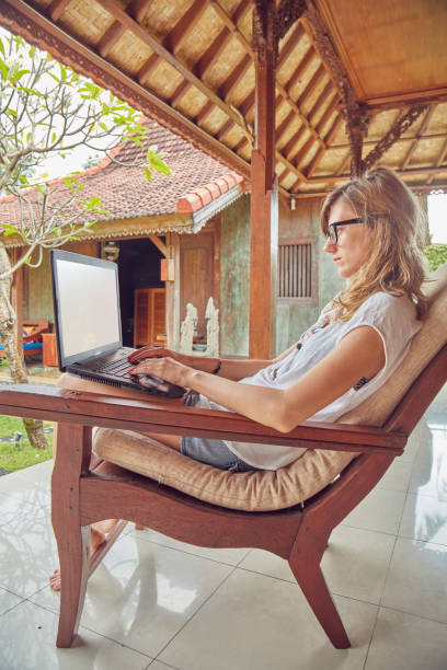 istock Girl using laptop on a home porch / terrace. 1149036481