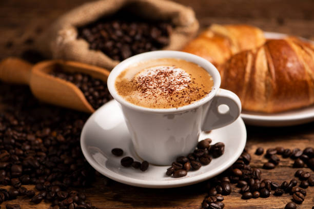 istock A cup of cappuccino with coffee bean as background 1149038581