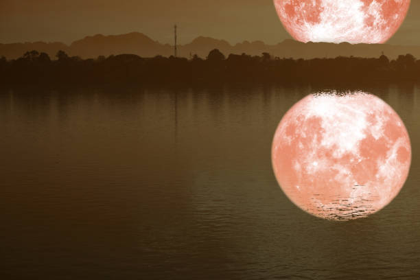 reflection on river of strawberry moon on night sky back silhouette mountain, Elements of this image furnished by NASA