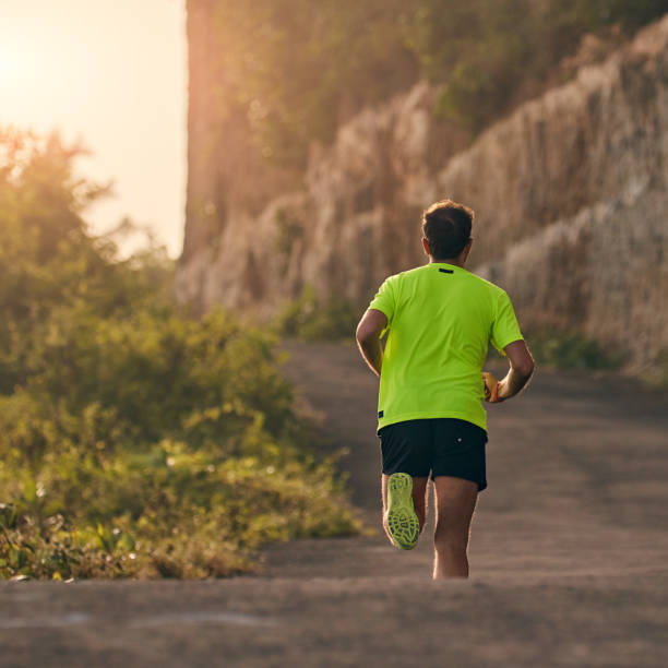 istock Man jogging on a downhill / uphill in suburb mountain road. 1149042059