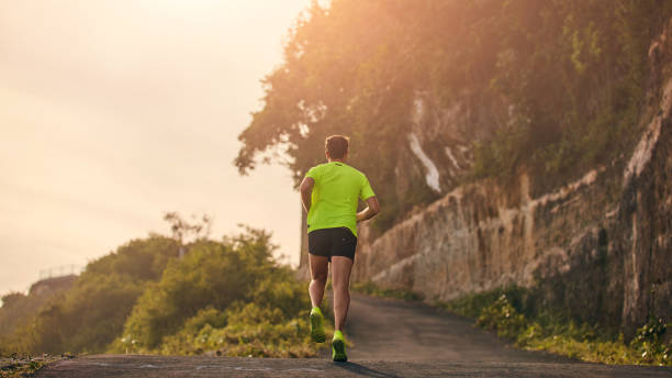 istock Man jogging on a downhill / uphill in suburb mountain road. 1149042432