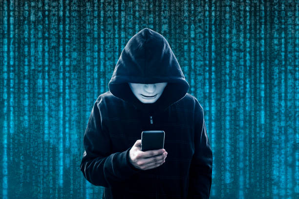 istock Hooded hacker with mask holding smartphone 1149046410