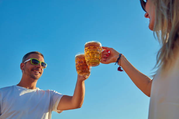 Young couple drinking beer outdoors and enjoying summertime.