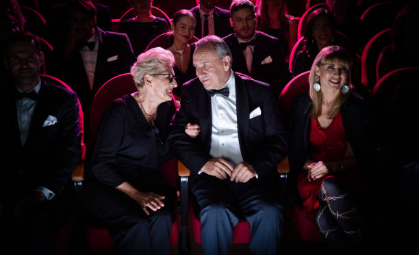 couples âgés parlant tout en s’asseyant dans le théâtre - tenue de soirée photos et images de collection