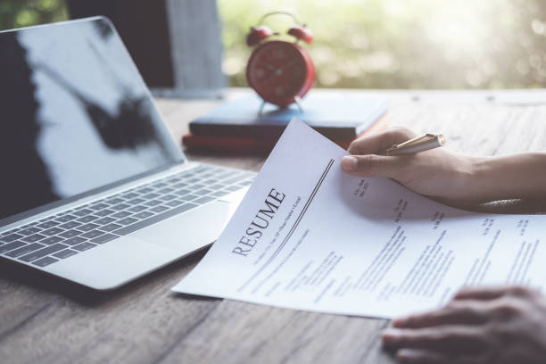 revisão do homem de negócio sua aplicação do currículo na mesa, computador portátil, seeker do trabalho - resume hire job applying - fotografias e filmes do acervo