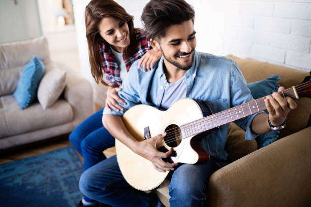 istock Young handsome man playing guitar for his girlfriend 1149054651