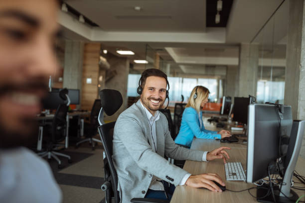 Call center office Handsome man working in a call center office. prop stock pictures, royalty-free photos & images