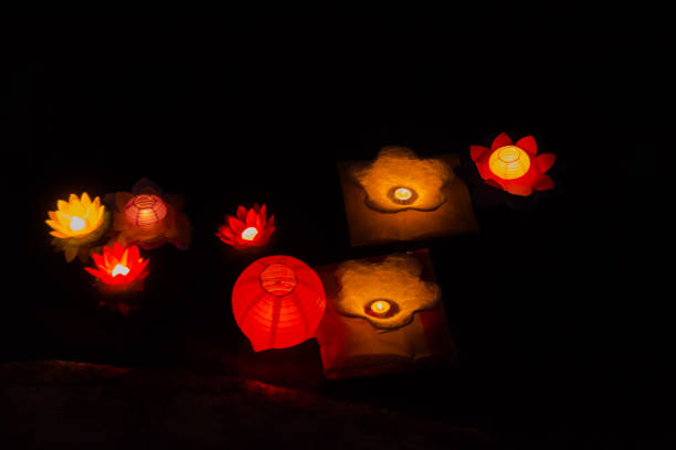istock Candle lanterns floating on a river among colorful reflections during night. 1149057643