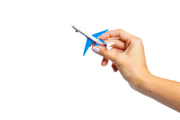 istock hand holding airplane toy model isolated on white background 1149058278