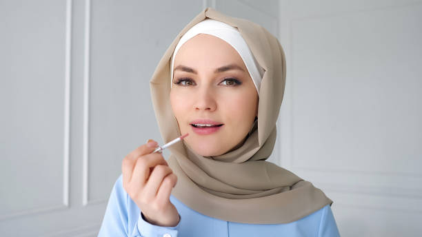 muslimische frau wendet kompaktes pulver mit blick auf spiegel. - veil human face women fashion model stock-fotos und bilder