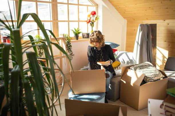 istock Woman Unpacking boxes at her new home 1149066785