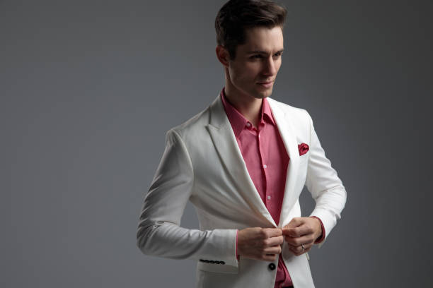 istock man in red shirt buttoning his suit and looking away 1149067940