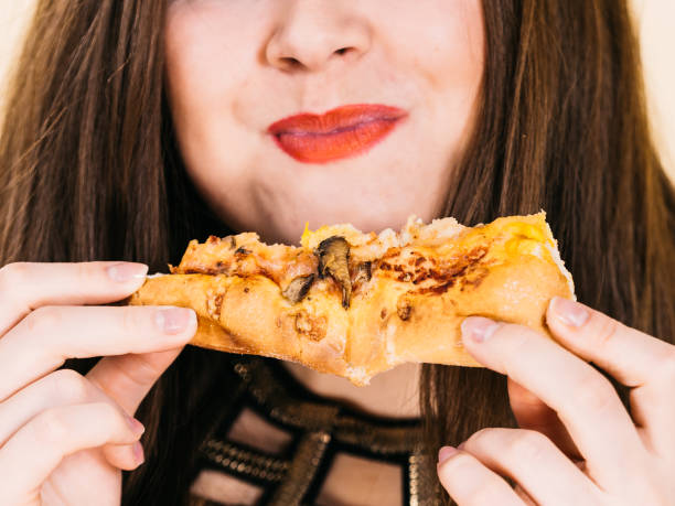 istock Woman eating hot pizza slice 1149069121