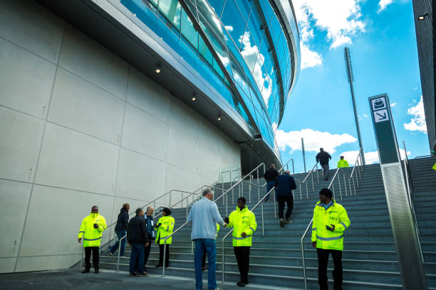 equipe de segurança fora do estádio novo de tottenham hotspur no dia do fósforo, londres, reino unido - football police officer crowd - fotografias e filmes do acervo