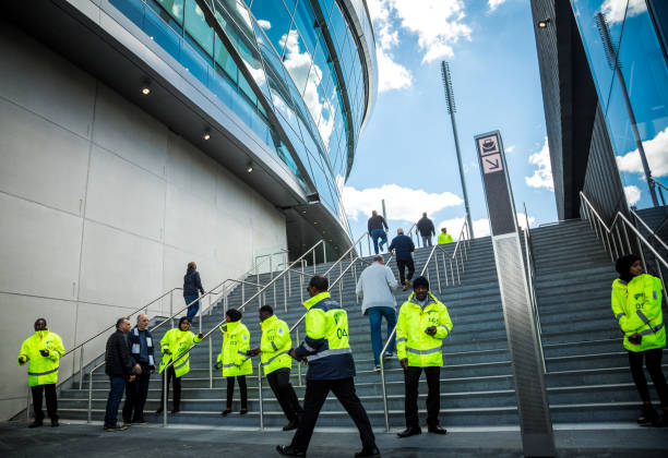 equipe de segurança fora do estádio novo de tottenham hotspur no dia do fósforo, londres, reino unido - football police officer crowd - fotografias e filmes do acervo