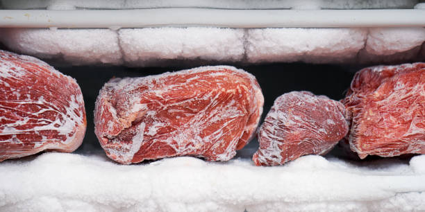 большие кусочки красного мяса в морозильной камере с большим количеством замороженного льда и снега - veal raw meat pink стоковые фото и изображения
